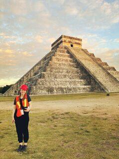 young woman standing in front of a Mayan temple